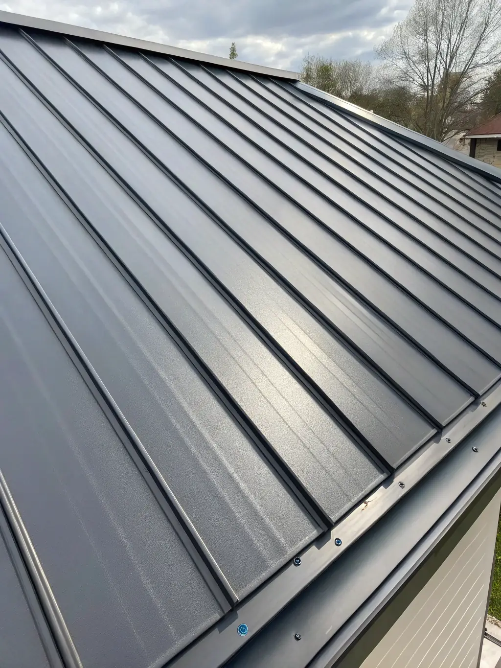 A close-up shot of a newly installed standing seam metal roof on a modern home in Richmond, VA, highlighting the clean lines and durable finish.